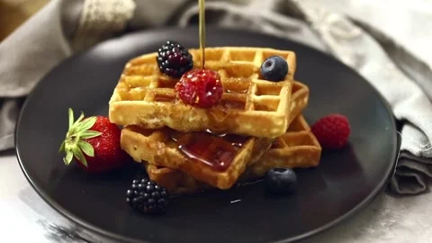 Shot of Pouring maple Syrup Onto waffle With mix Berries. Stock-Footage 336589406