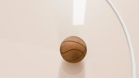 Shot release sending basketball falling and spinning onto cream court in arena, Stock Footage 333629267