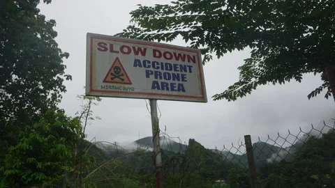 Shot from roadside level, a warning sign stands in misty Philippine mountains Video stock 319982509