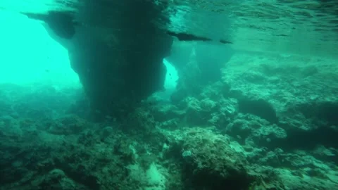A Shot of rocky ocean bottom inside of weather worn sea cave Stock Footage 155402114