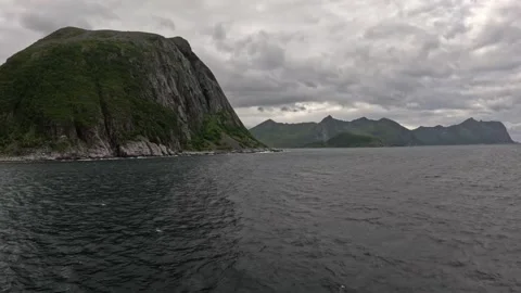 Shot sailing past massive rocky cliff headland at Gryllefjord exit in Norway Vídeos de archivo 342755845