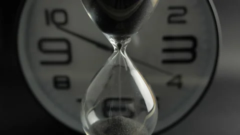 Shot of a sand clock measuring time while the sand is falling down against  Stock Footage 138099780