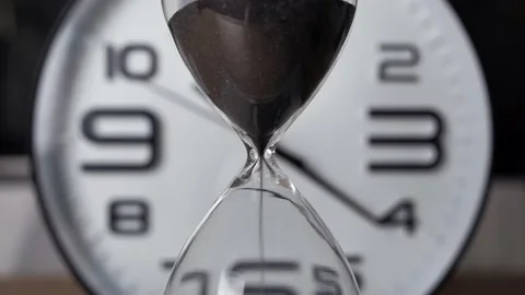Shot of a sand clock measuring time while the sand is falling down against Stock Footage 138275148