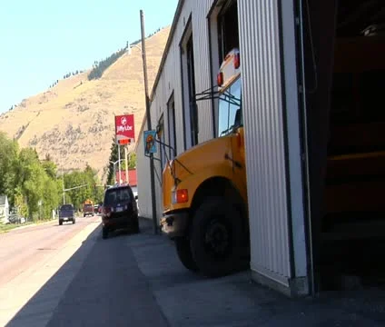 Shot of schoolbus pulling out onto street Stock Footage 21624253