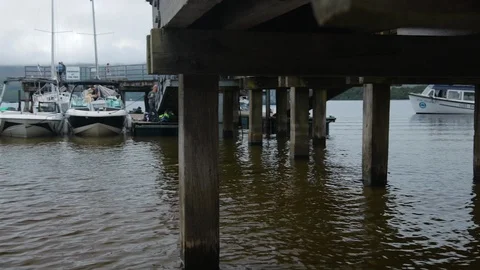 Shot from side of Pier panning across to focus on the water with boats. Stock Footage 100570988