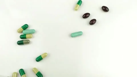 Shot Slow Motion Video many different types of pills and vitamin falling on a Stock Footage 136039668