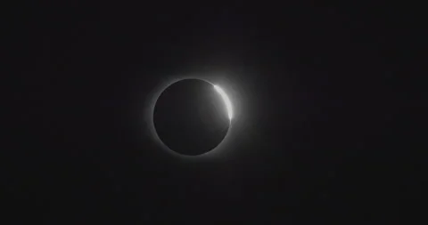 A shot of a solar eclipse forming a diamond ring shot in DCI 4K 24p Stock Footage 245972873