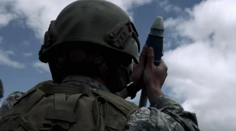 Shot of soldier loading mortar tilting down to firing trigger. Stock Footage 52257528