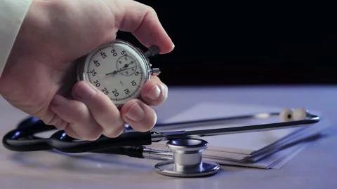 A shot of stethoscope with stack of cards and stopwatch in a hand Stock Footage 235155541