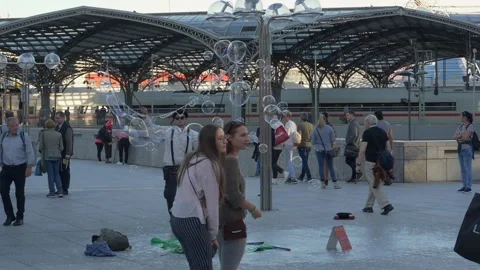 A Shot of Street Performer Creating Soap Bubbles Near Train Stock Footage 332104326