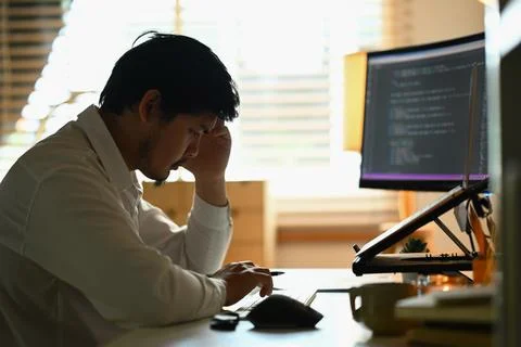 Shot stressed male software developer programming code on computer screen Stock Photos