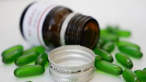 Shot of tablets bottle with open cap and tablets around Vidéo 147696961