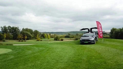 A shot of a Tesla on a golf field Stock Footage 115992419