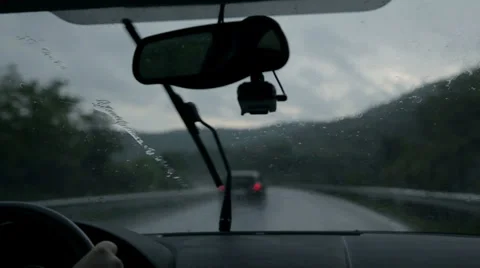 Shot through windscreen while driving on motorway on rainy evening Stock Footage 32462237