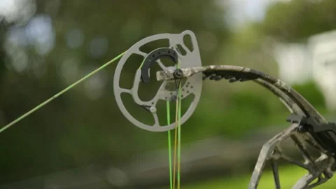 A shot of the top Cam of a compound bow as the bow is drawn and fired. Vídeos de archivo 139261269