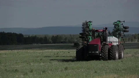 Shot of a tractor working in in a field, compressing the grass Stock-Footage 79333595