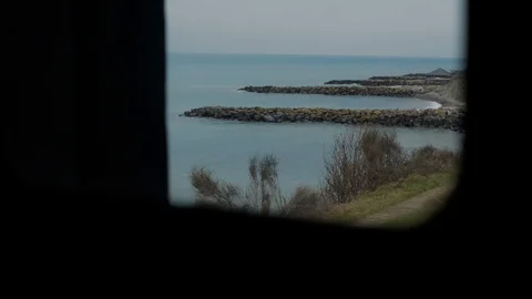 Shot from train window when railway goes into distance,on sides sea and grass Video stock 128241023