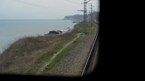 Shot from train window when railway goes into distance,sides sea and mountains Stock Footage 128241249