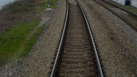 Shot from train window when railway goes into distance,sides sea and mountains Stock Footage 128241314