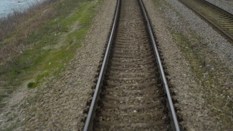Shot from train window when railway goes into distance,sides sea and mountains Stock Footage 128241399