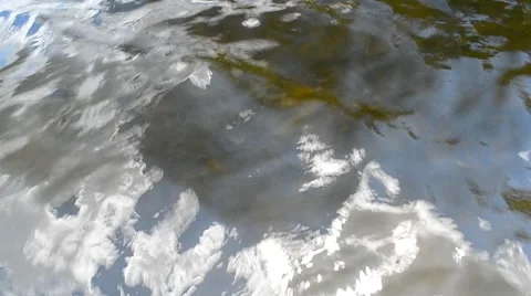 Shot of water surface with small waves, reflected partly cloudy sky and glimpses Stock Footage 52853081