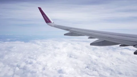 Shot from the window of flying plane showing wizzair logo and clouds Stock Footage 122260428