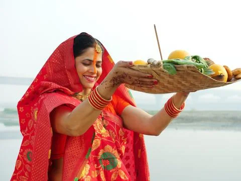 Shot of a woman posing for the camera while standing in a river - Chhath Pooj... Stock Photos