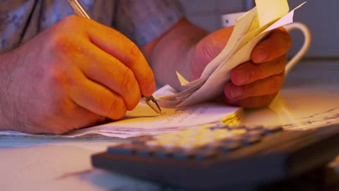 Shot of writing down expense numbers from bills into a ledger book Video stock 336980486