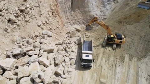 Shot of yellow crawler excavator loading dump truck with sand at construction Stock Footage 219952132