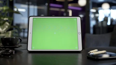 In this shot you can see tablet device with green screen placed on table Stock Footage 103167976