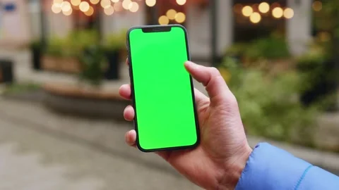 Shot of young hands man holding a mobile telephone with a vertical green screen Stock Footage 145843498