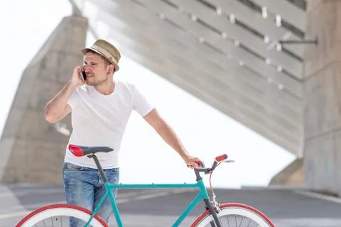 Shot of a young man using his cellphone while going to work with his bicycle Foto stock