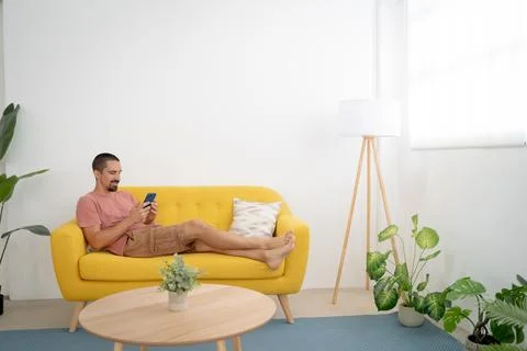 Shot of a young man using his smartphone to send text messages. Stock Photos