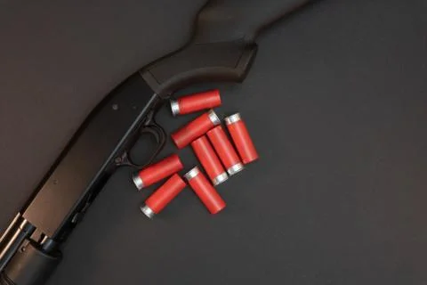 Shotgun and shells on table. Stock Photos