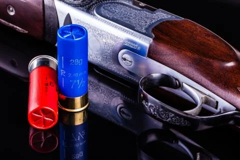 Shotgun on black with shells Stock Photos