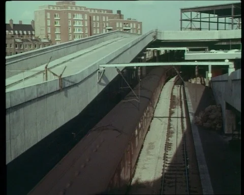 Shots of long train driving through train station with people near it, UK 1966 Stock Footage 132329191