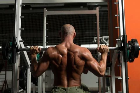 Shoulder exercises on a smith machine Stock Photos