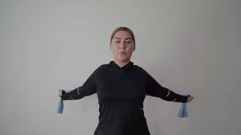 Shoulder Pass-Through Mobility Drill With Resistance Band at Home Stock Footage 340545131