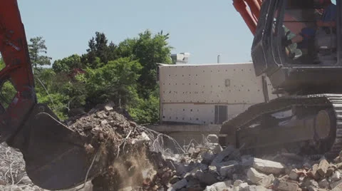 Shovel excavator, drops bricks on construction site. Stock Footage