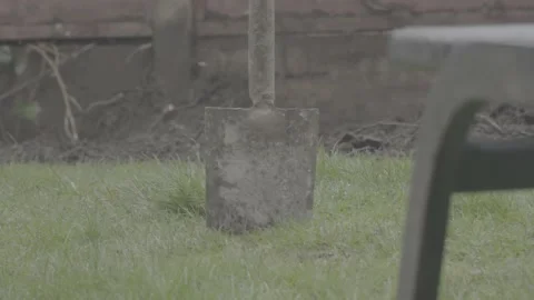 Shovel in ground as rain pours down 스톡 동영상 154749639