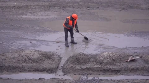 A shovel worker drains a puddle from a construction site Stock Footage 147436516