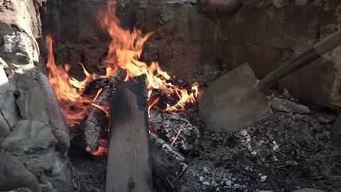 Shoveling ashes in the fire pit in 60FPS Stock Footage 179022602