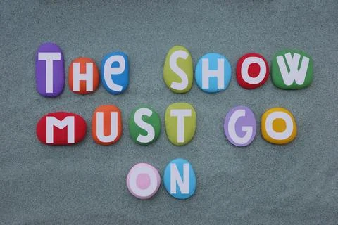 The show must go on, text composed with hand painted multi colored stone letters Stock Photos