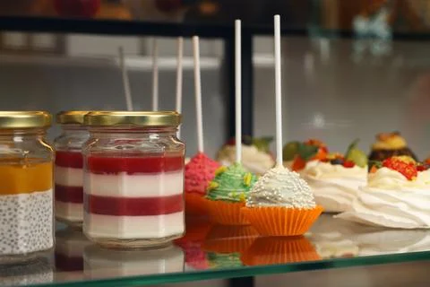 Showcase with different tasty desserts in store, closeup Stock Photos