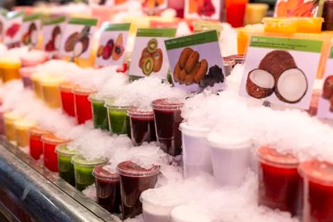 Showcase with different types of colorful cold juice and smoothie in the ice on Stock Photos