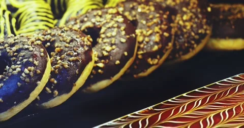 Showcase with donuts covered with multi colored glaze. Delicious sweets with Stock Footage 255839383