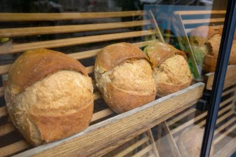Showcase shelf with round breads in bakery Stock Photos