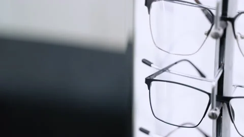 Showcase with spectacles in modern ophthalmic store. Glasses on display on wall Stock Footage 231674386