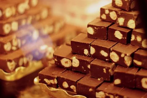 A showcase with sweets laid out in a stack. chocolate nougat with nuts Stock Photos