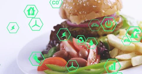 Showcasing centered white plate on tabletop with sesame burger, fries, salad, Stock Photos